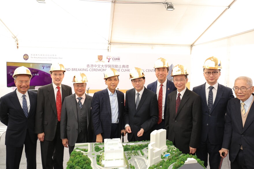 Guests stand near a scale model of The CUHK Medical Centre.

