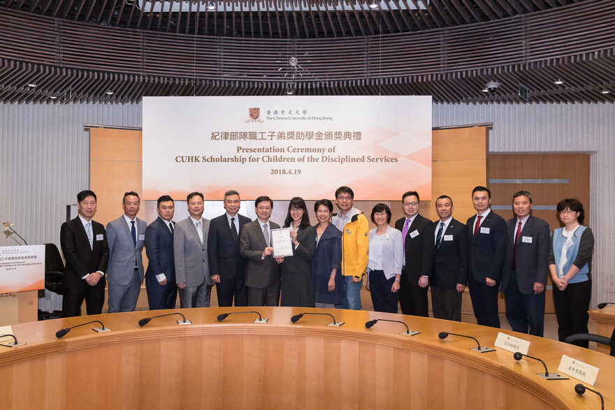 The Honourable Lee Ka-chiu, John presents a certificate to Lee Kiu-wing (7th from left).
