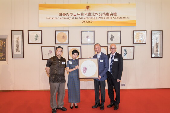 Dr Xie Chunling (2nd left) and Mr Chen Keng (1st left) present an oracle bone calligraphy to Professor Fok Tai-fai, Pro-Vice-Chancellor and Vice-President of CUHK and Dr Scotty Luk, Director of University Health Service.