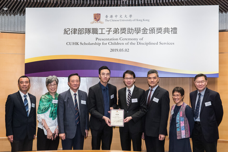 保安局副局长区志光先生颁发奖状予张剑谦同学（左四）。